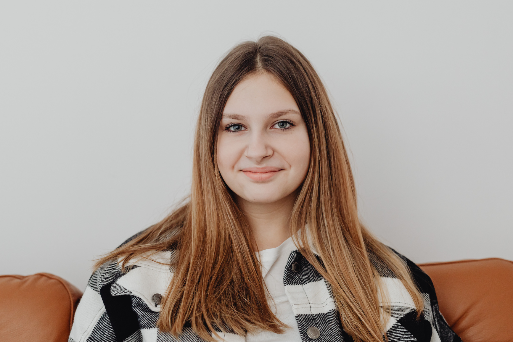A smiling young woman sitting on a sofa