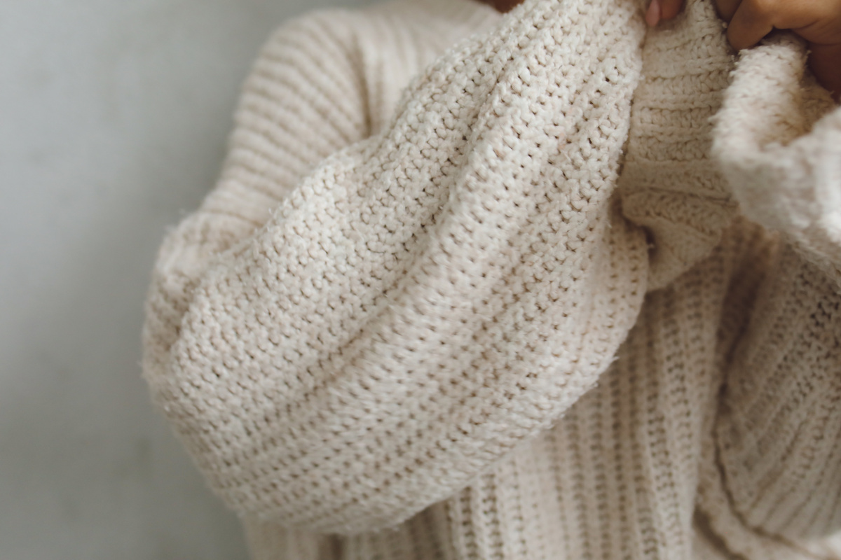 Someone in a cosy cream knitted jumper